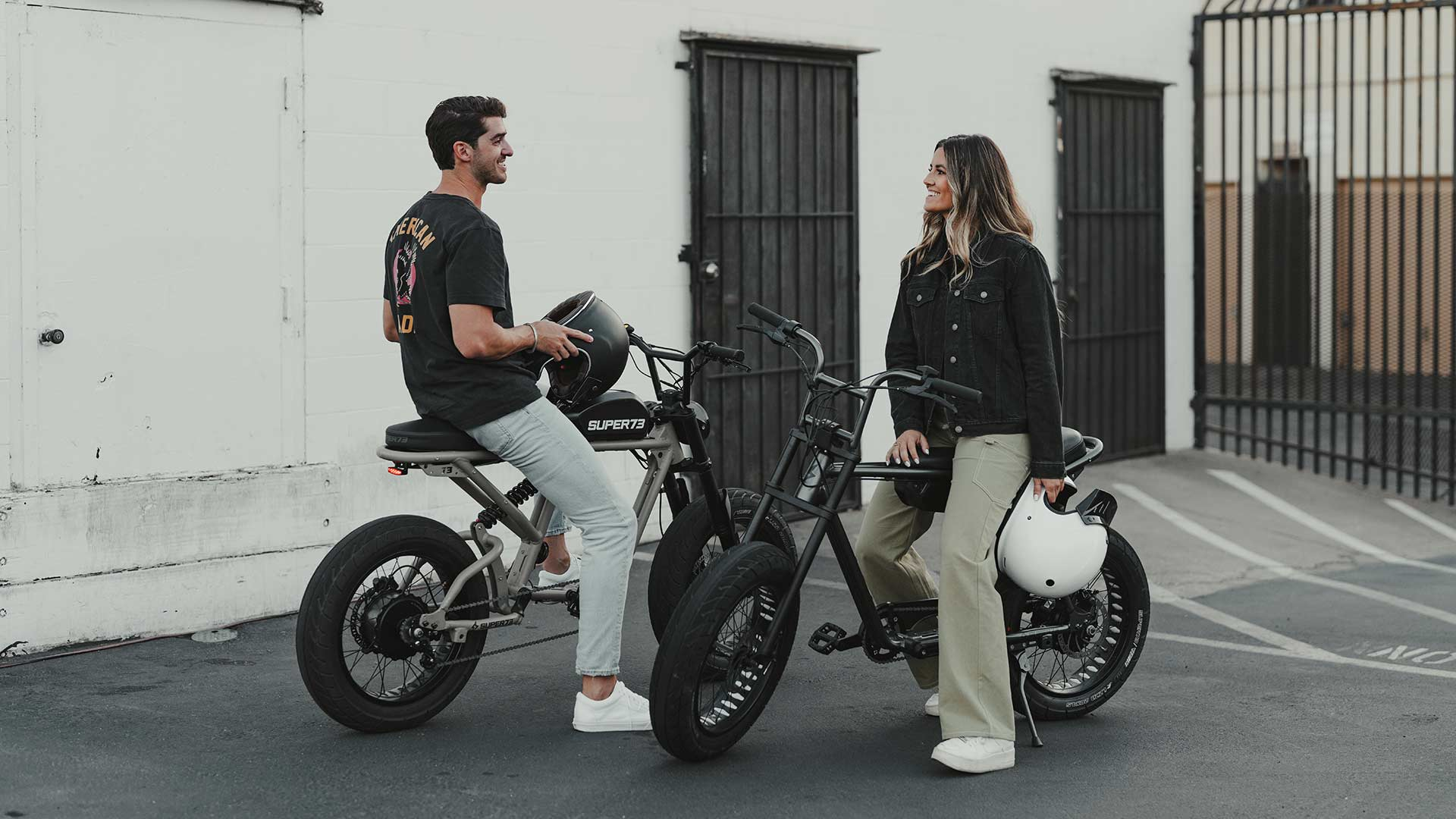 A man and a woman sitting on two Super73 ebikes
