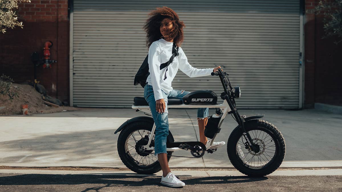 FILE--A woman rides an electric bike past a fashion boutique of