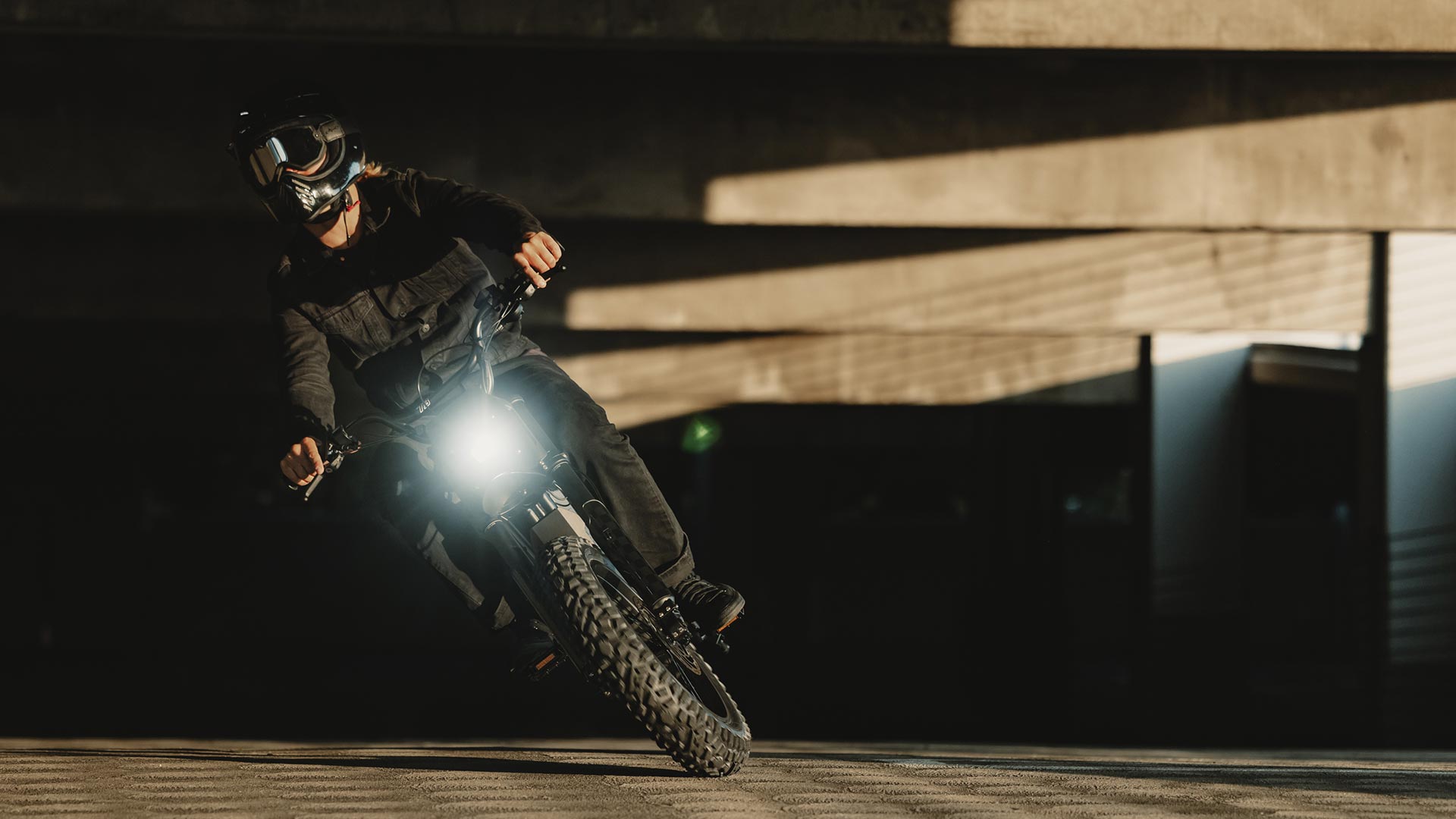 Image of a person riding the SUPER73-R Blackout SE ebike in a parking garage.