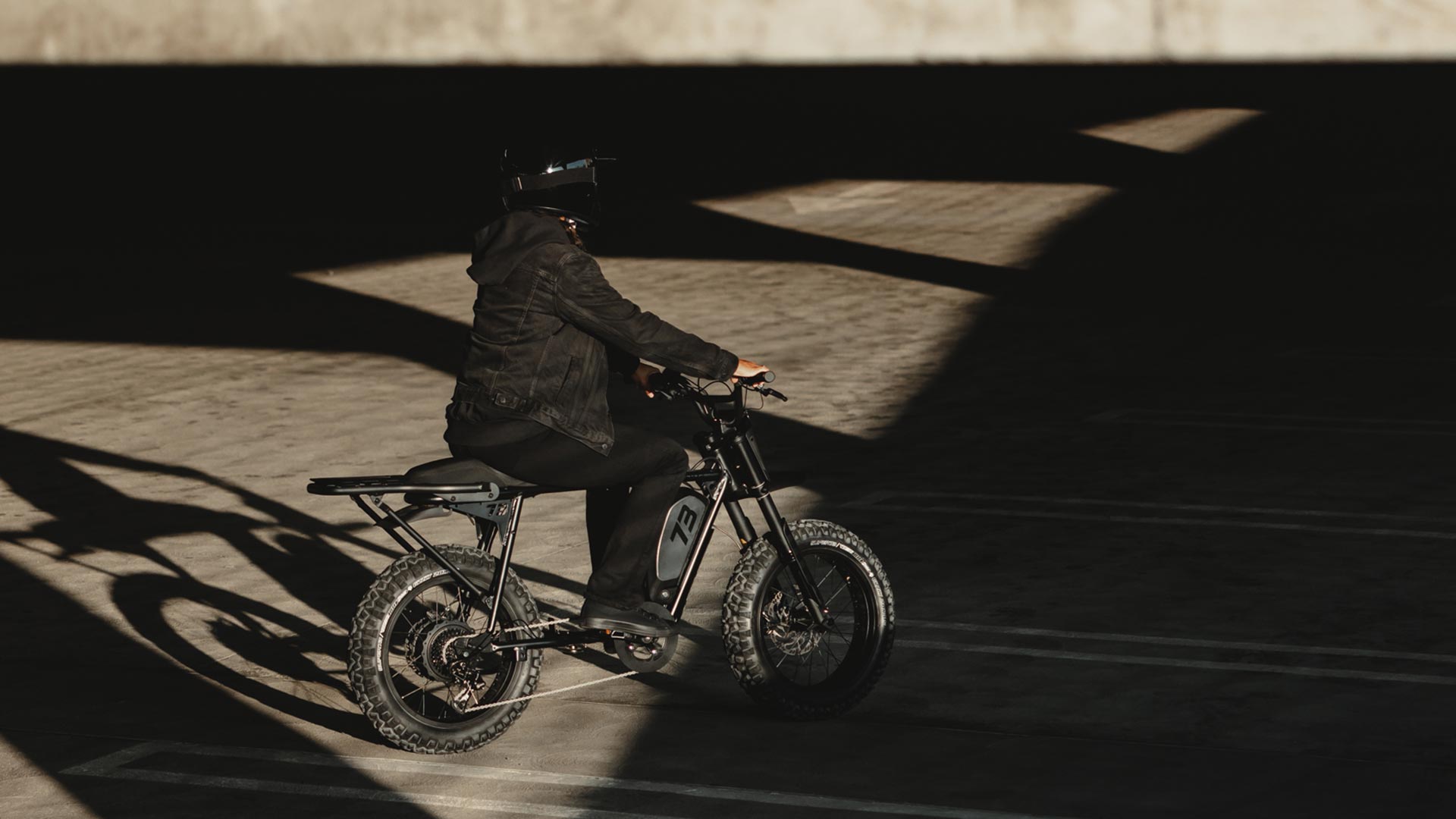 Image of a person riding the SUPER73-S Blackout SE in a parking garage.