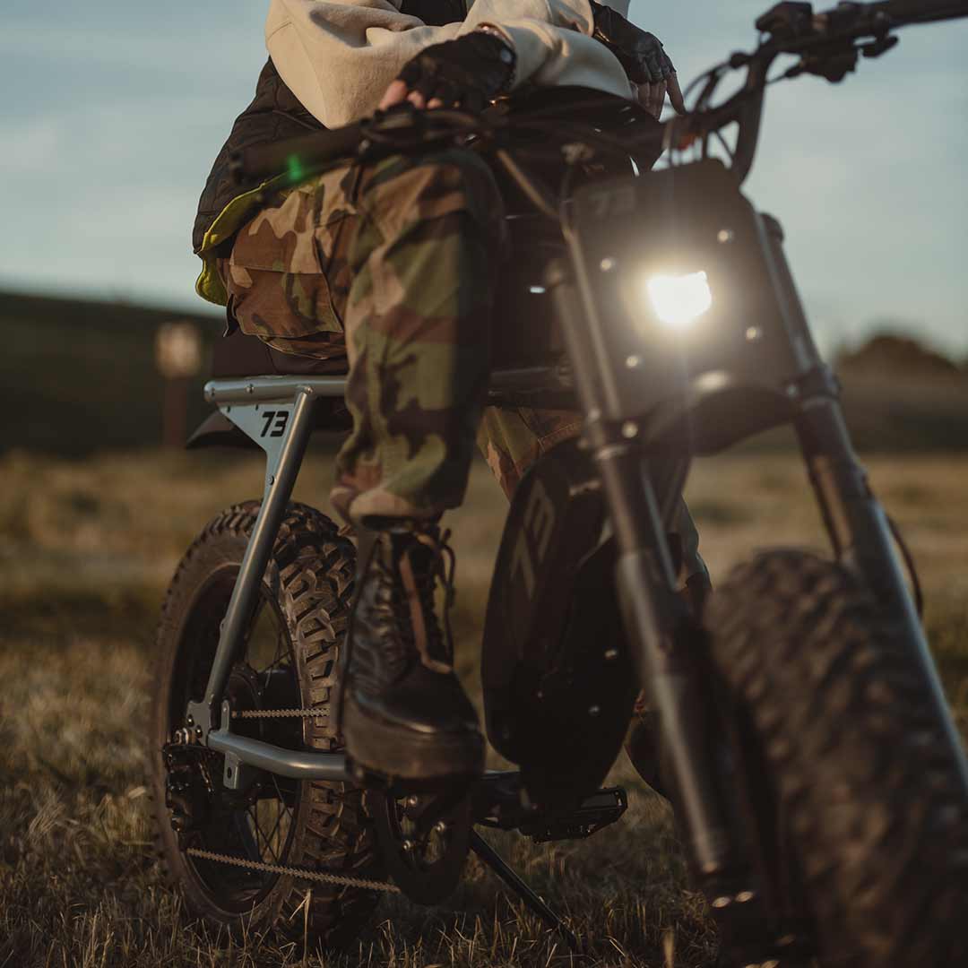 Lifestyle image of a rider riding the S Adventure on a grassy field and wearing a helmet.