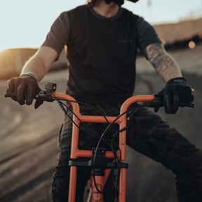 Man wearing 100% Super73 Cognito Gloves on  a Super73-ZG Astro Orange